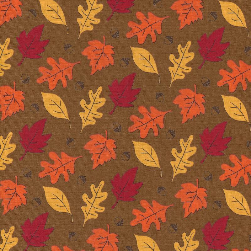 fabric featuring orange, yellow and red leaves and acorns on a tan background