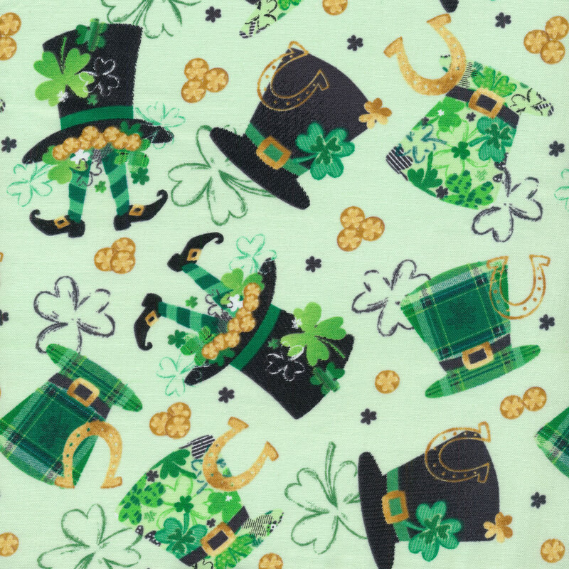 light green fabric covered in leprechaun hats with various patterns on them, shamrocks, horseshoes, and pieces of gold