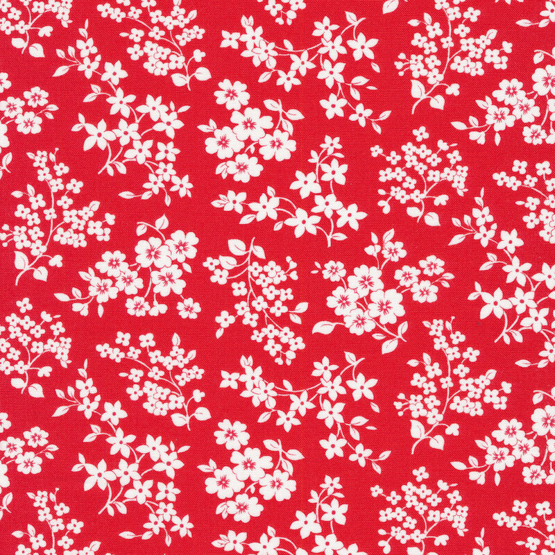 Red fabric with white clusters of stemmed flowers tossed all over.