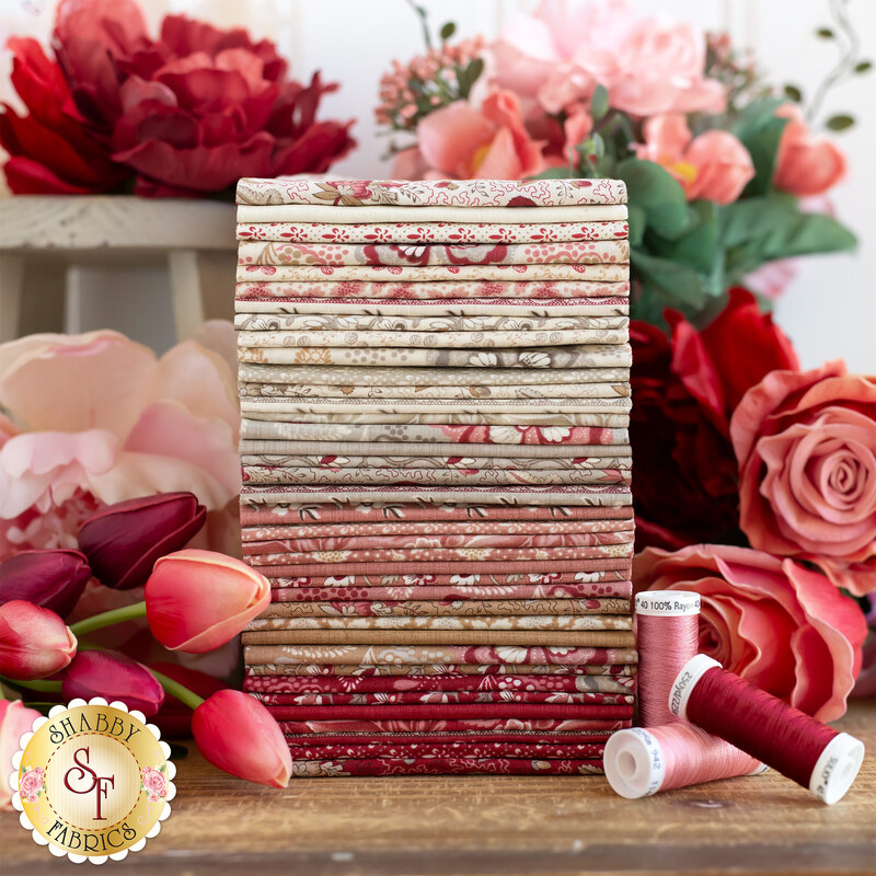 gorgeous muted fabric stack in shades of cream, beige, dusty pink, and faded red, surrounded by matching threads and florals 