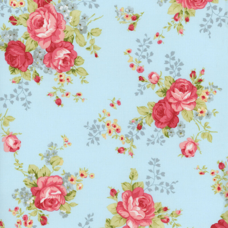 Floral fabric with a light cream background featuring large pink roses and small blue and yellow flowers, accented by rosebuds and lush green leaves