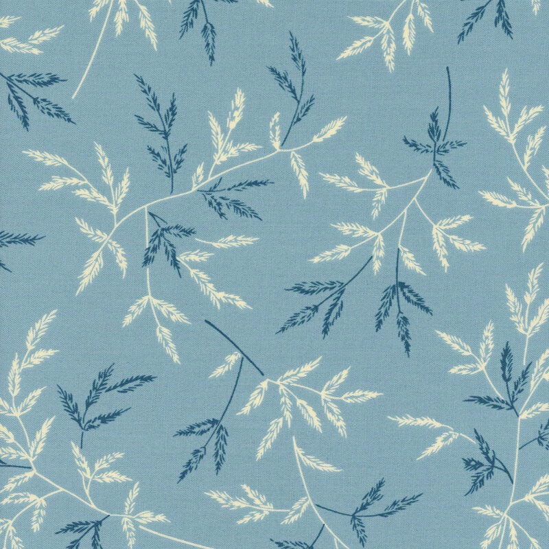 fabric featuring a background of medium blue with dark blue and cream branches spread across it