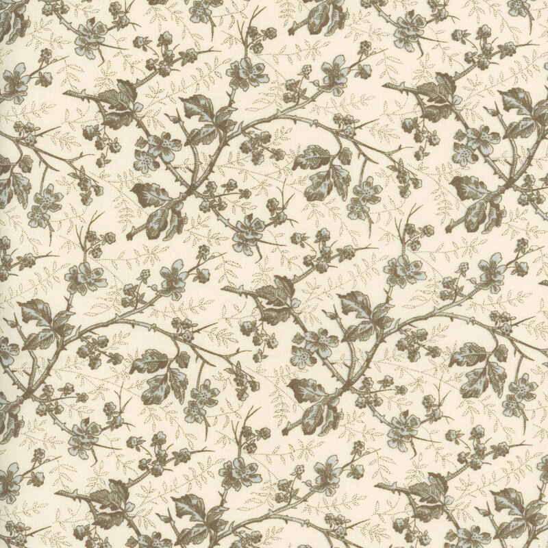 fabric featuring an array of light blue and brown branches with leaves and flowers on them, set on a cream background