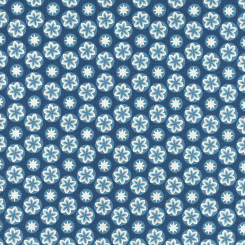 fabric featuring a medium blue circular design, each circle containing blue and cream accented flowers and stars, set on a dark blue background