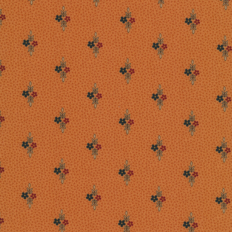 Fabric that features small motifs of red and dark blue flowers with sprigs of leaves on a burnt orange background.
