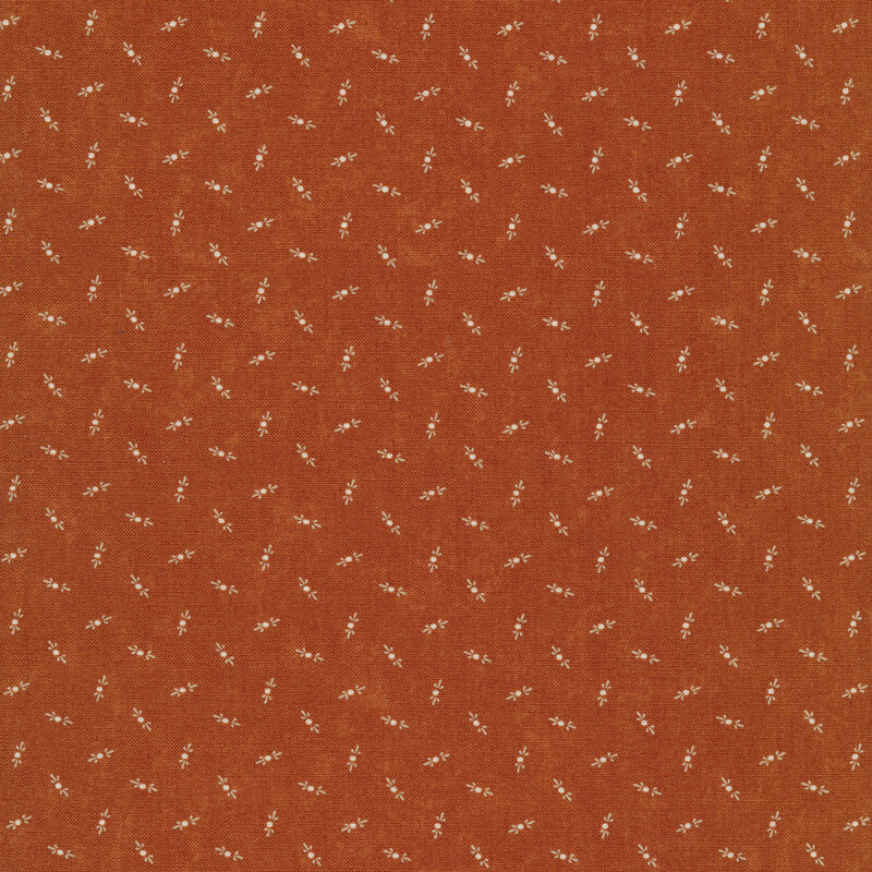 Fabric that features tossed cream motifs on a mottled burnt orange background.