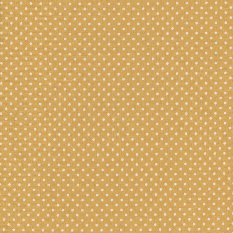 this fabric features a sandy golden background with white ditsy polka dots