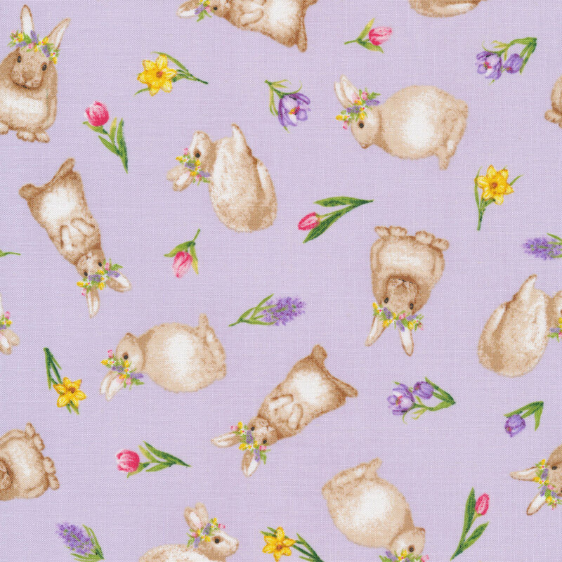 This fabric features tossed bunnies with flower crowns and tossed spring flowers on a pastel lilac purple background.