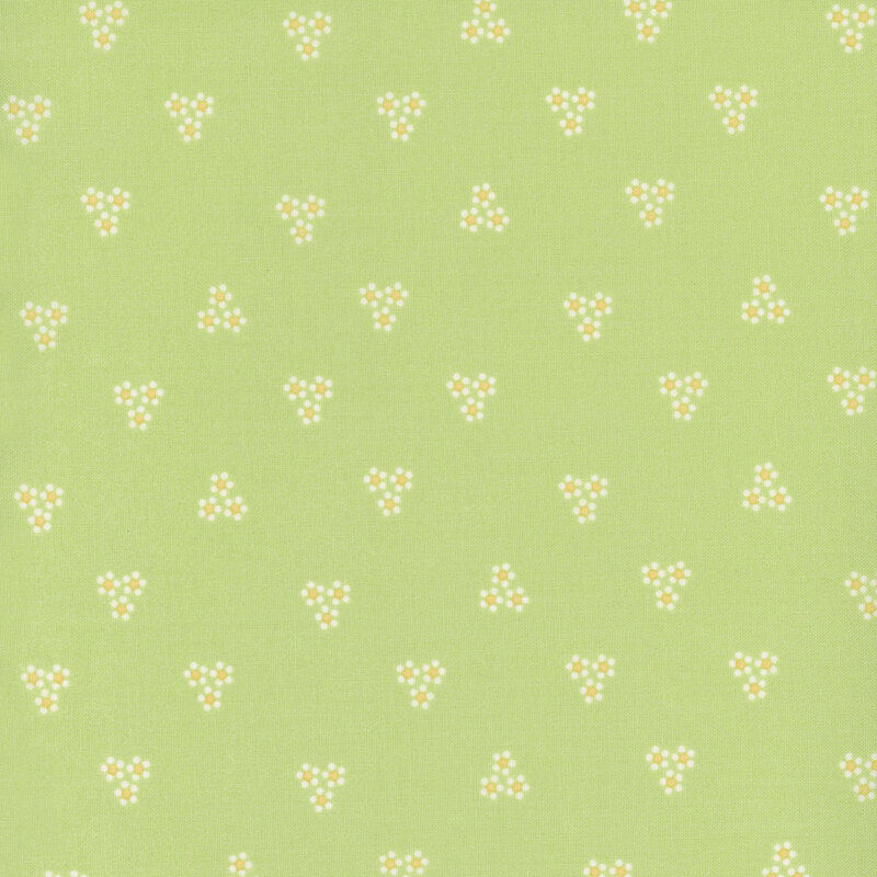Image of fabric featuring clusters of flowers made out of groupings of small dots, set against a green background