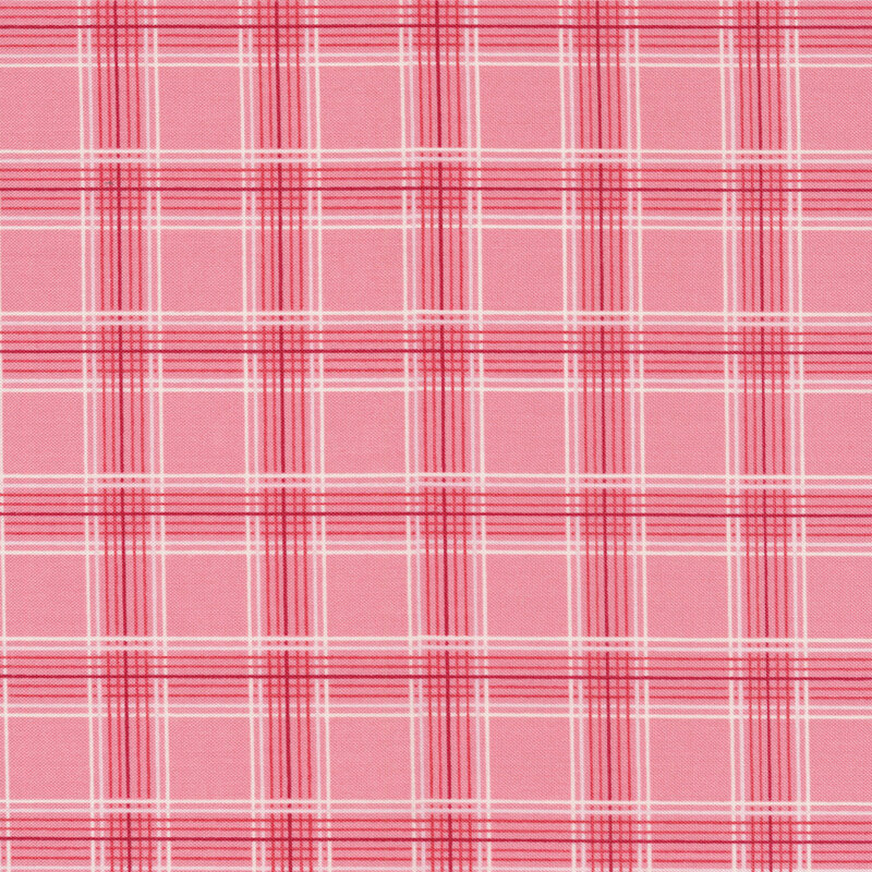 This fabric features a lovely thin-lined red and cream plaid print on a pink coral background