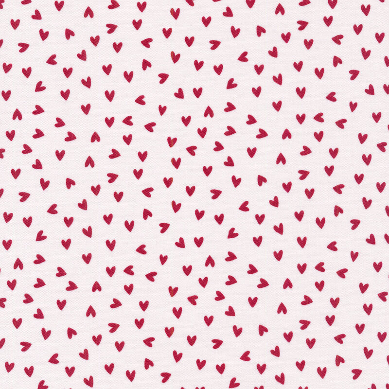 This fabric features bold red ditsy tossed hearts on a white background.