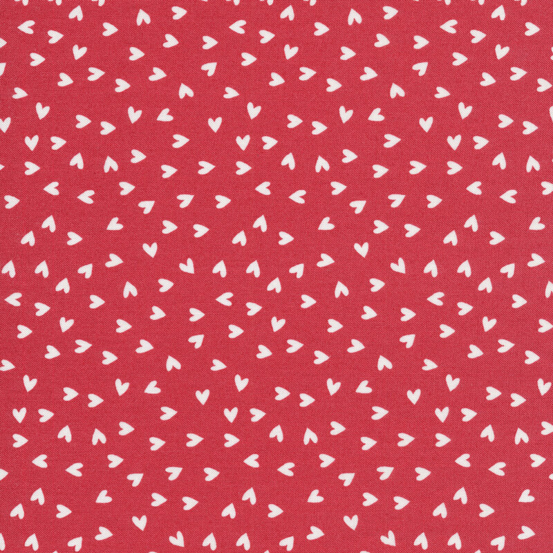This fabric features white ditsy tossed hearts on a coral pink background.