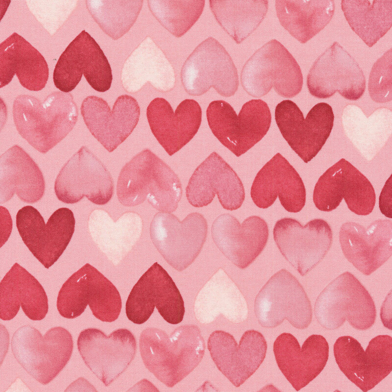 fabric featuring rows of watercolor pink and red hearts on a lovely coral pink background