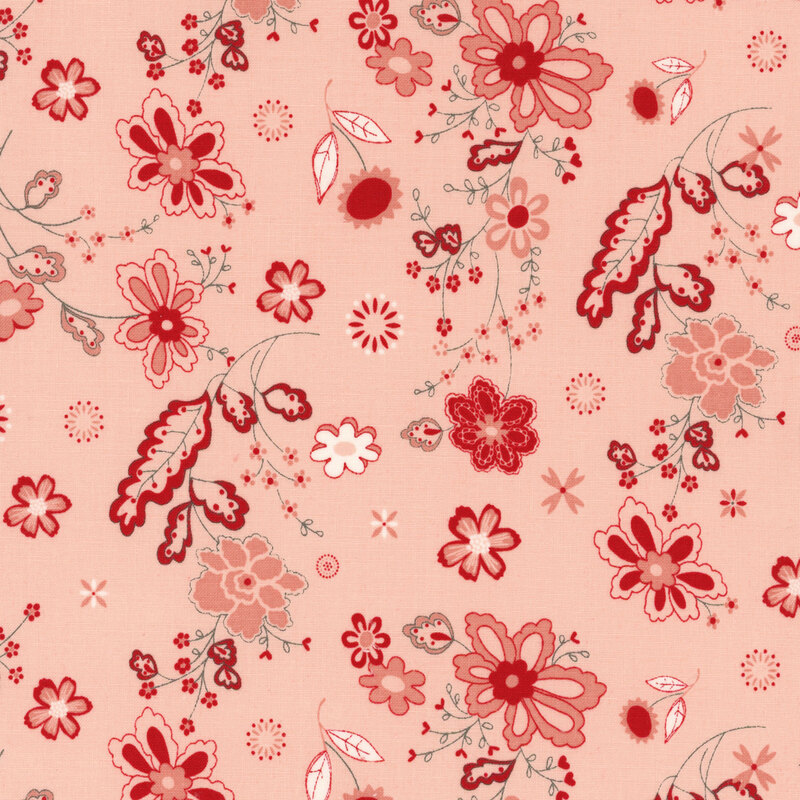 fabric featuring red, gray and white florals and vines in a paisley style on a solid blush background