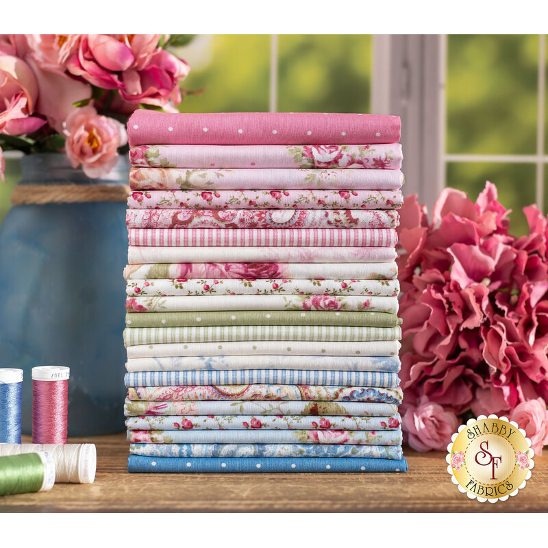 pink, blue, and green floral themed fabrics fabrics stacked on a wood table