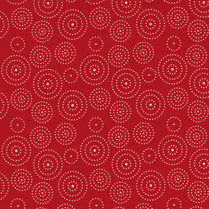fabric featuring circles of various sizes composed of cream dots on a red background