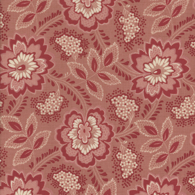 Floral fabric decorated with large pink, cream and red flowers and bunches of small white flowers on a clay pink background