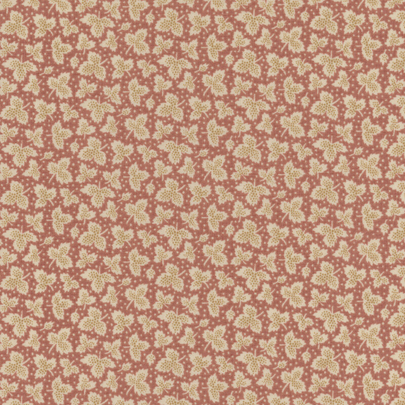 Fabric with light cream tossed leaves and small dots against a dusty pink background.