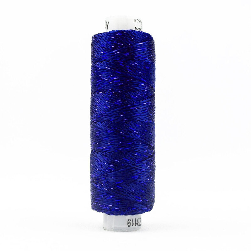 A deep blue-purple shimmering rayon thread on a white spool