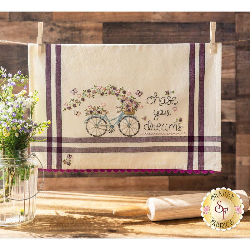Finished embroidered dish towel with a bicycle with flowers and the words 