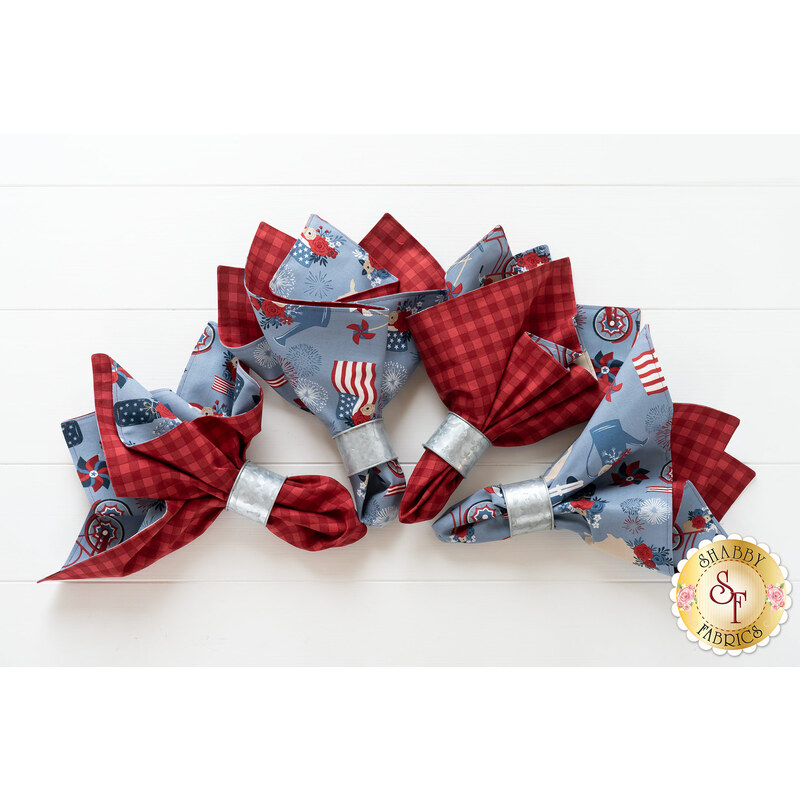 Reversible cloth napkins with flags and patriotic motifs on blue on one side, and red tonal gingham on the other.