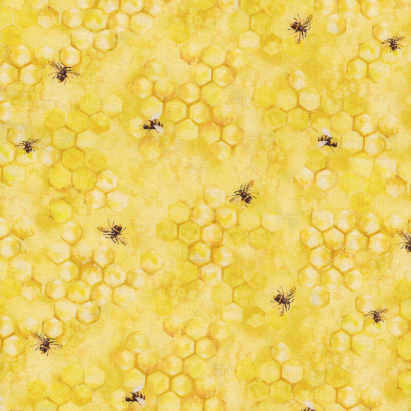 This fabric features honey comb print with honey bees tossed on a bright yellow background.