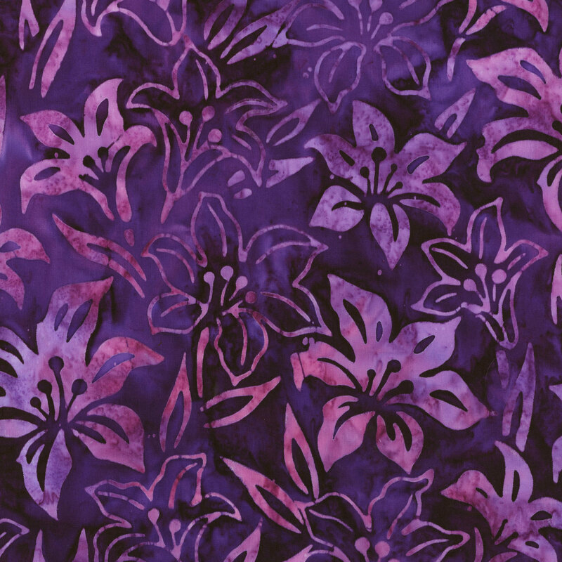 fabric featuring light purple and pink mottled lilies and leaves on a dark purple mottled background