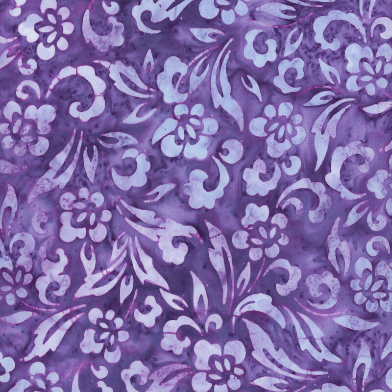 this fabric features light purple and blue flowers, scrolls and leaves on a medium purple-blue background