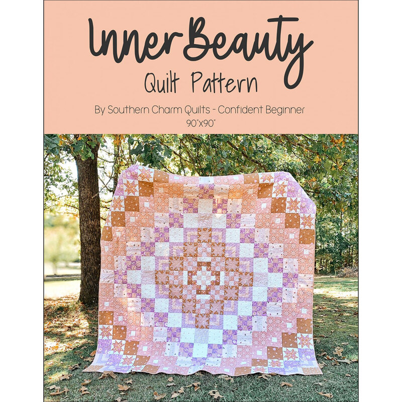 The front of the Inner Beauty pattern by Melanie Traylor showing a large geometric quilt being held up outdoors