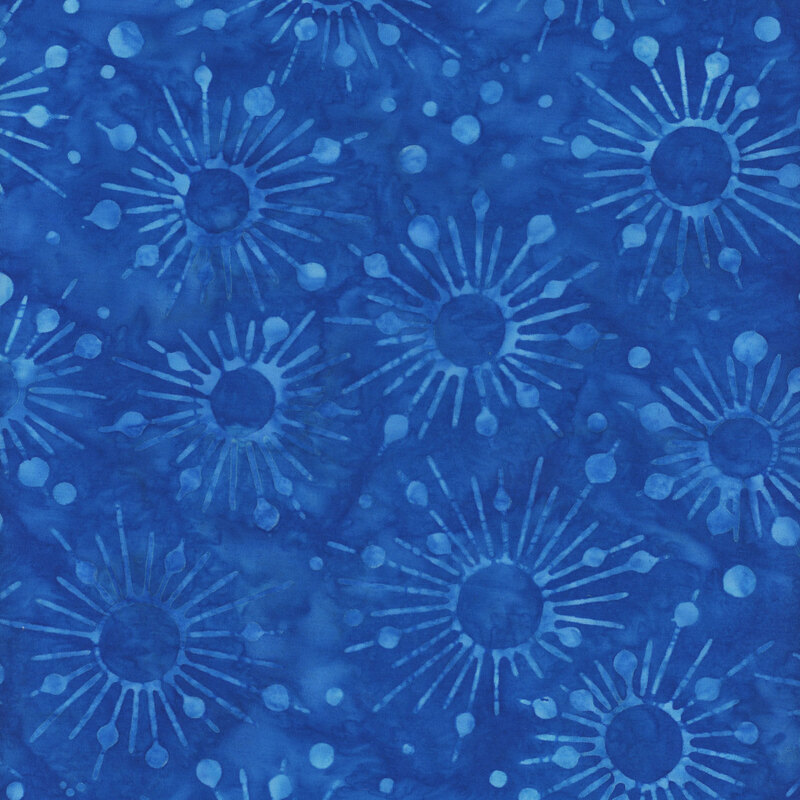 Tonal blue mottled batik fabric with lighter blue starbursts and dots all over a royal blue background