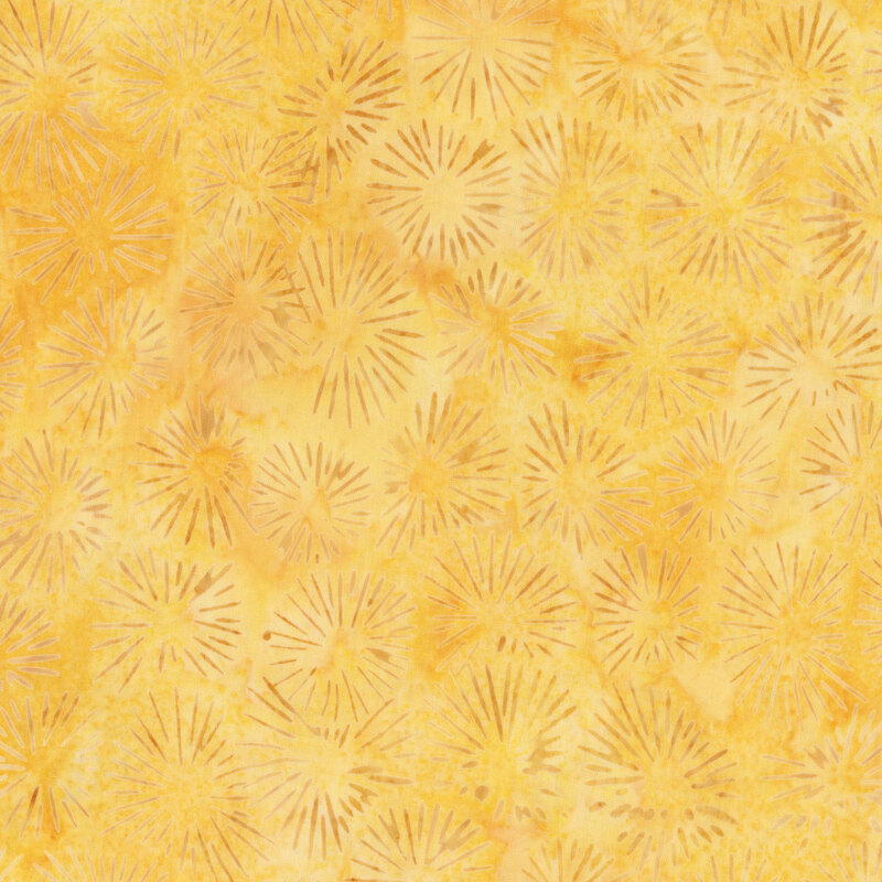 A light yellow mottled batik fabric with sun burst designs