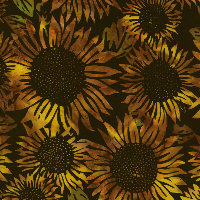 Batik with a brown, almost black background, with bright yellow sunflowers mottled with brown in the foreground, with the occasional green leaf peeking through