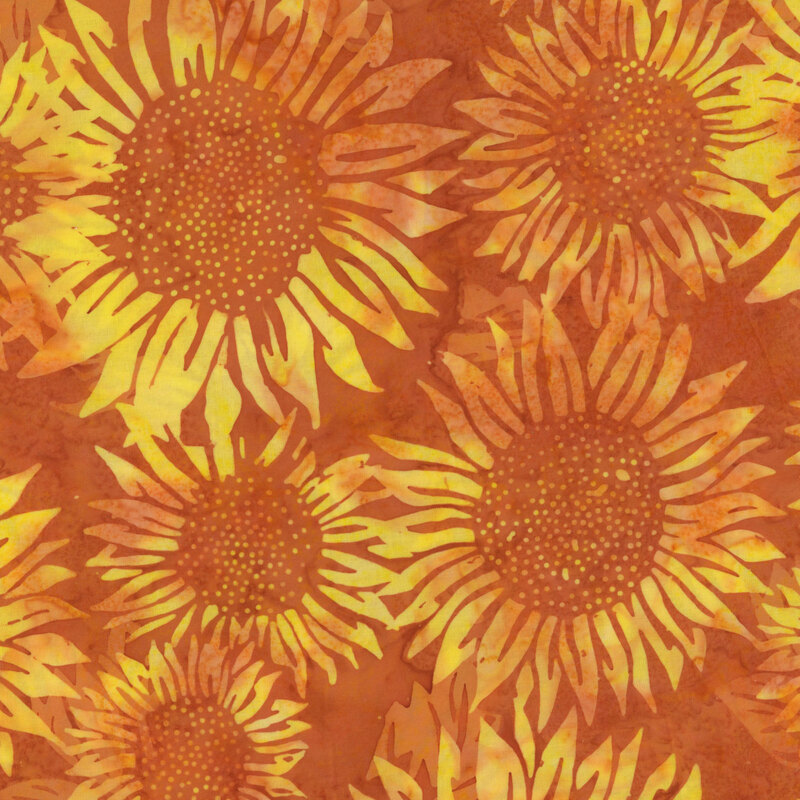 orange mottled batik fabric with large tonal sunflowers all over