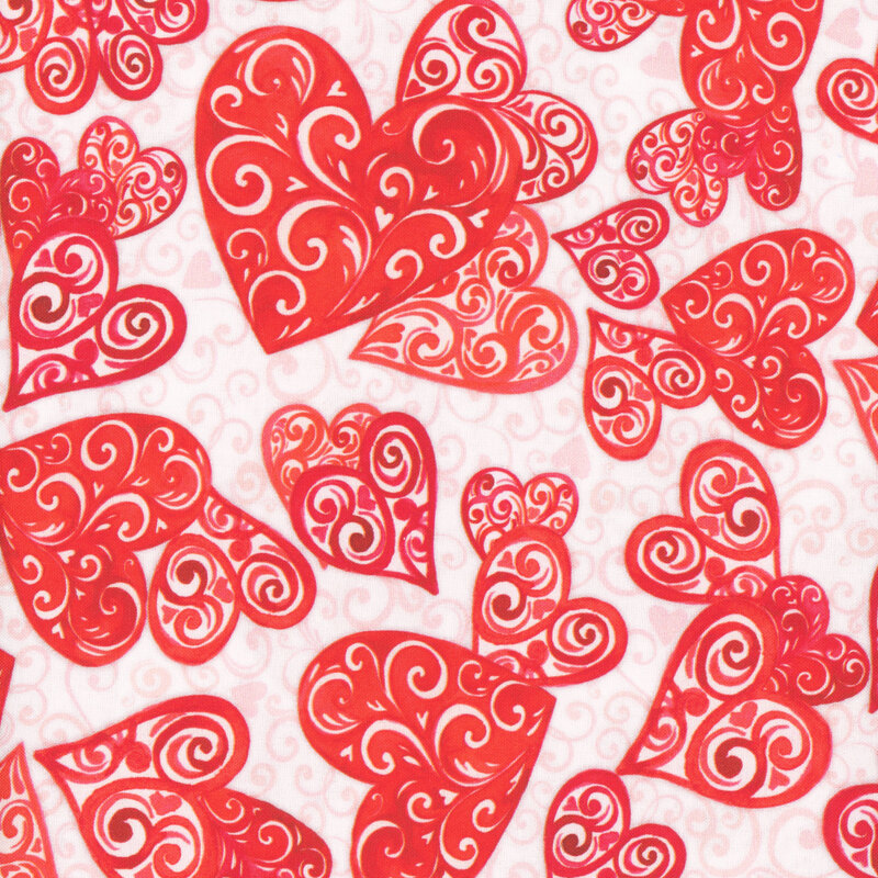 fabric featuring red hearts of varying sizes composed of swirls in the foreground, set against a white background with light pink swirls and tiny hearts on it