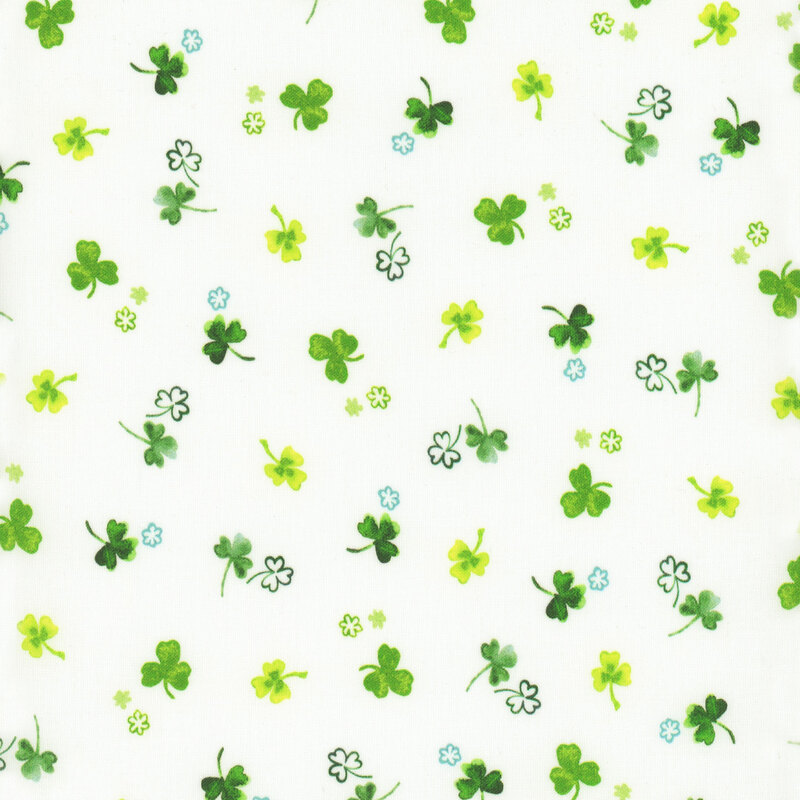 Scan of fabric featuring tossed three-leaf clovers in varying shades of green on a white background