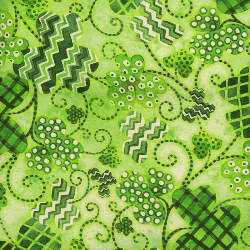 Scan of fabric featuring three-leaf clovers of various sizes, shades of green, and patterns, connected by dotted swirls and set against a cloudy light green background