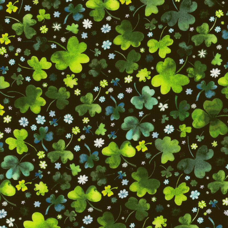 Scan of fabric featuring tossed three-leaf clovers in various sizes and shades of green, interspersed with small flowers and set against a black background