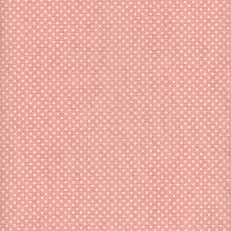 A pink fabric with small white polka dots all over