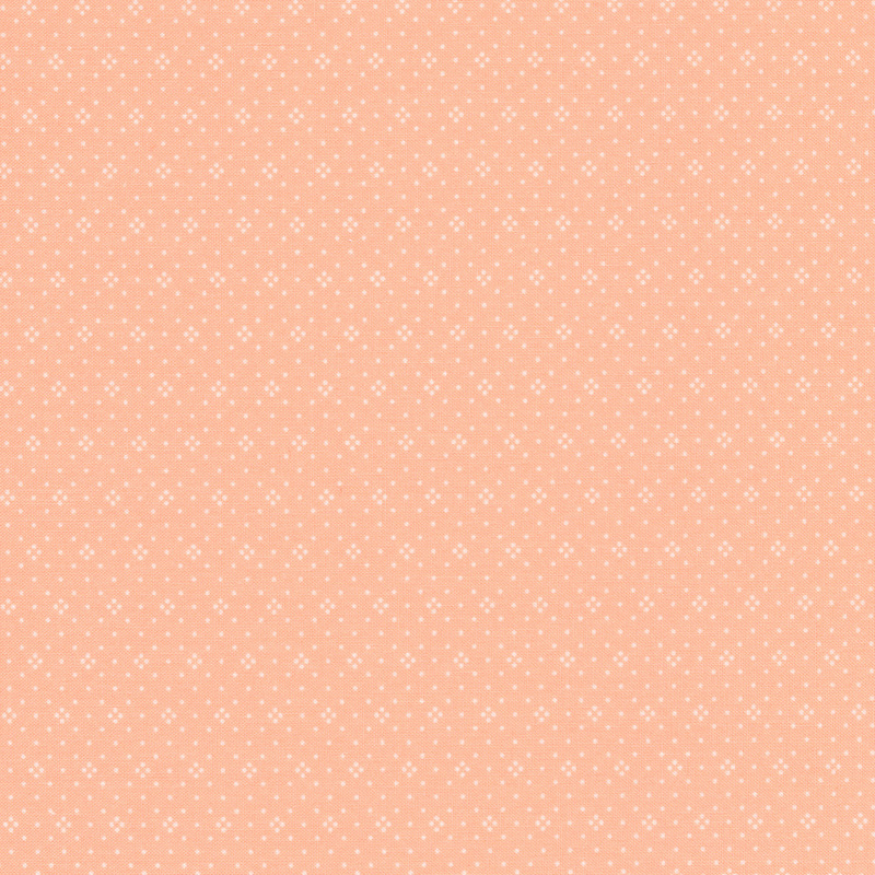 Light cantaloupe colored fabric with small white dots all over