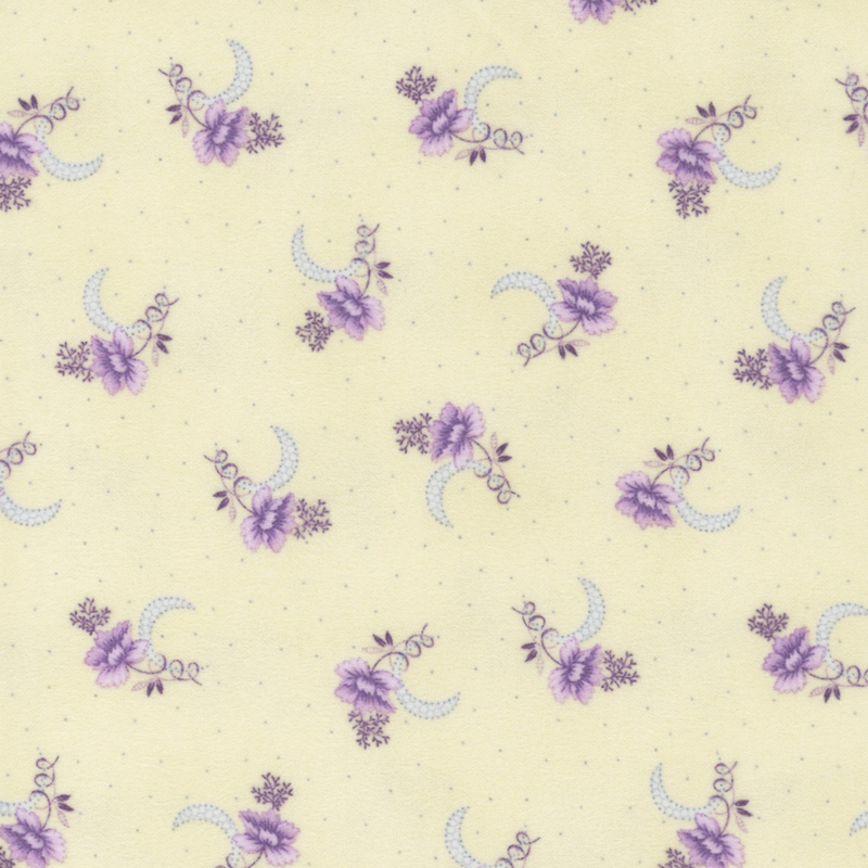 flannel fabric featuring scattered purple flower clusters with blue crescent moons on a cream background