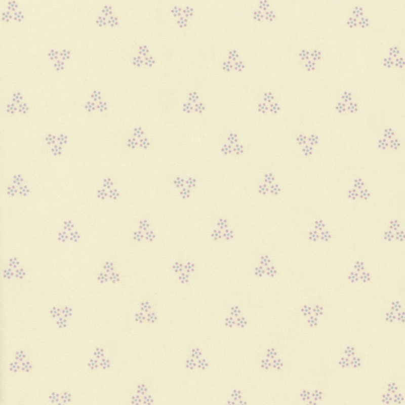 flannel fabric featuring light purple floral cluster motifs scattered on a cream background