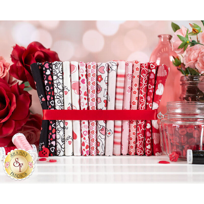 red, pink, white and black valentine themed fabrics wrapped in a red ribbon