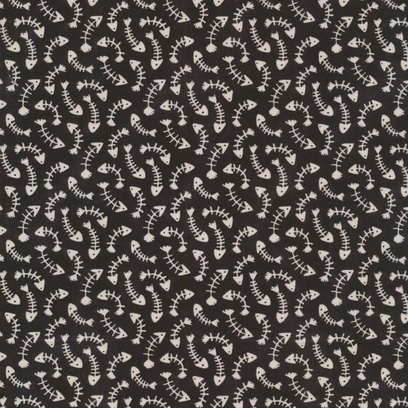 This fabric features tossed white fish bones on a black background.