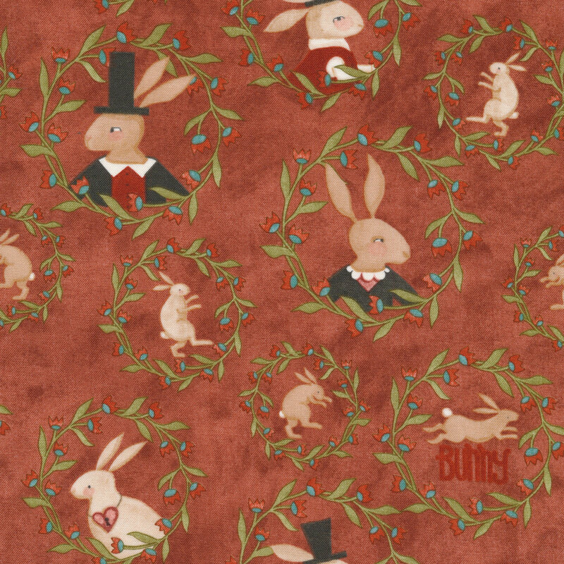 This fabric features wreath motifs with bunny portraits on a brick red background.