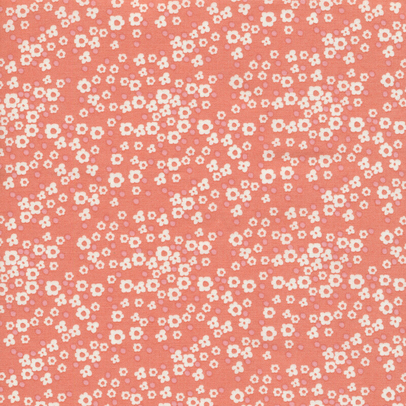 coral fabric with various sizes of packed white flowers and small tonal dots.