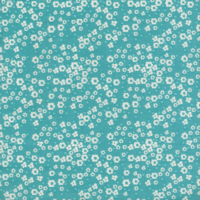blue fabric with various sizes of packed white flowers and small tonal dots.