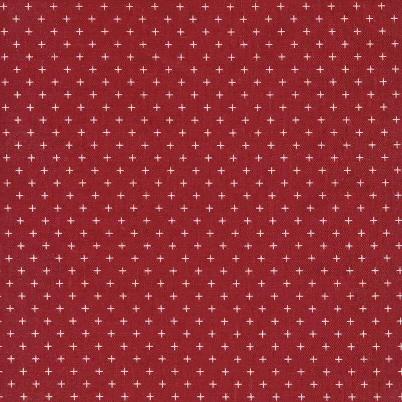 This fabric features a dark red background with geometric white cross motifs.