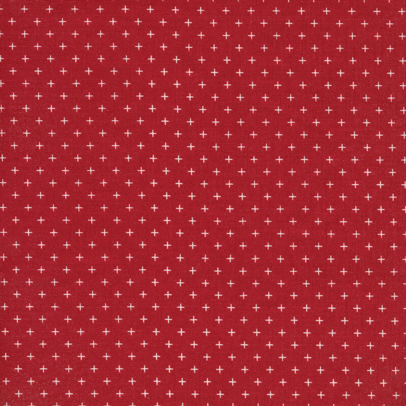 This fabric features a red background with geometric white cross motifs.