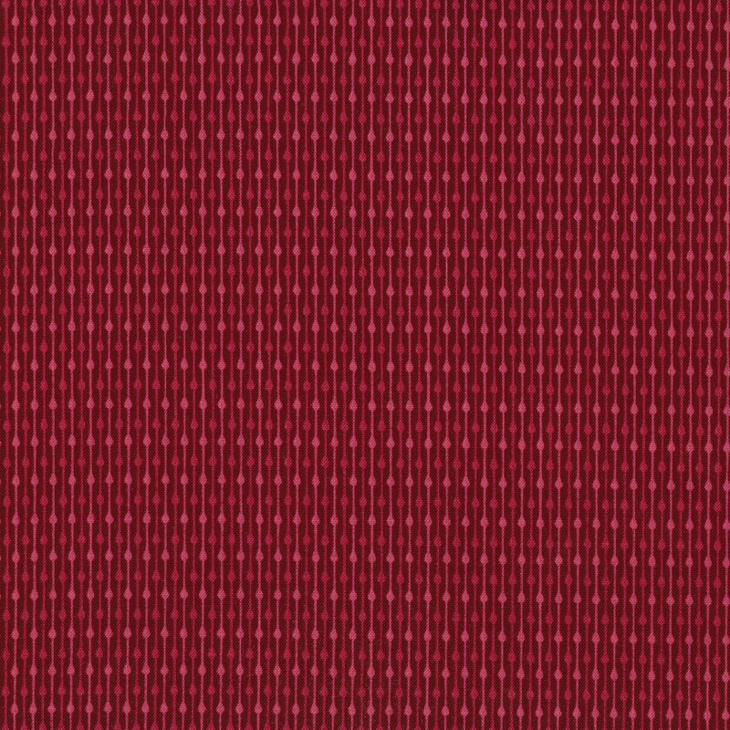 This fabric features pink tonal thin stripes with dots on a dark red background.