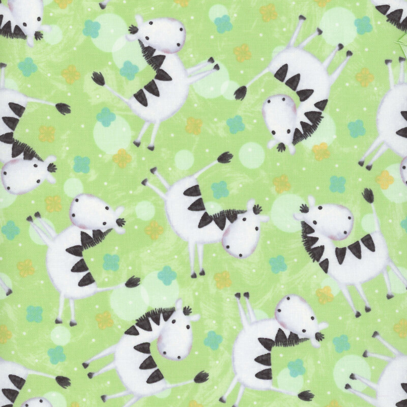 fabric featuring zebras tossed on a light green background with turquoise and yellow scalloped flower-like motifs